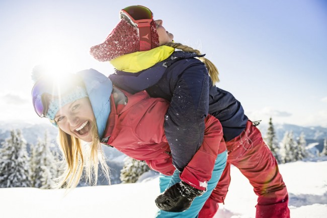 Mutter mit Kind im Schnee in Flachau