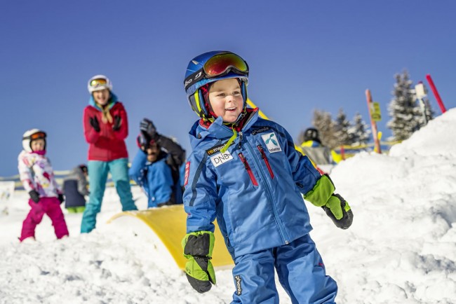 Kinder üben skifahren auf der Piste in Flachau
