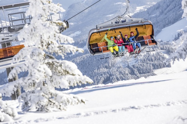 Skifahrer in der Seilbahn über der Piste in Flachau